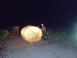 Strażacy zepchnęli balot na pobliskie pole