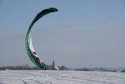 Ten wielki latawiec ciągnie na specjalnych linkach amatora snowkite`ingu


