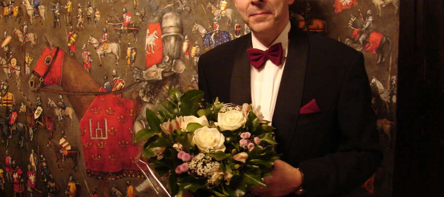 Wojciech Popielarz po koncercie w Brukseli na tle jednego z obrazów Grunwald Art 2010