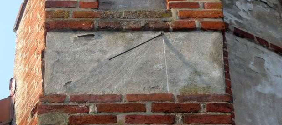 Jeden z zegarów słonecznych na murze kościoła w Wozławkach