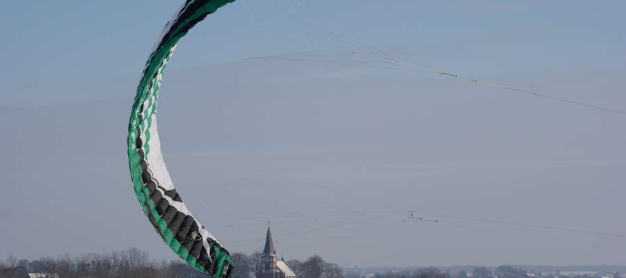 Ten wielki latawiec ciągnie na specjalnych linkach amatora snowkite`ingu


