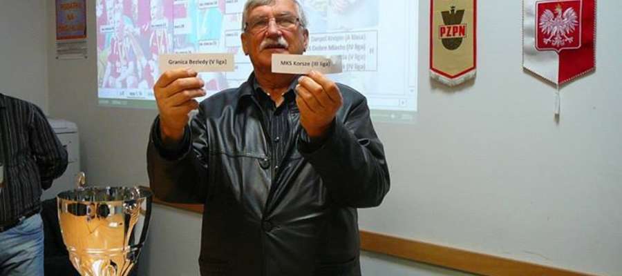 Szymon Czyżewski z WMZPN prezentuje kartki z nazwami klubów Granica Bezledy i MKS Korsze