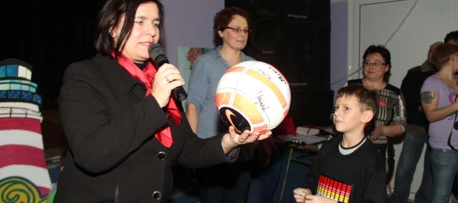 Burmistrz Jolanta Piotrowska przekazuje piłkę zwycięzcy licytacji