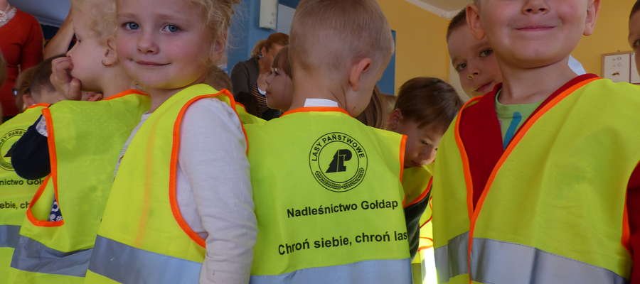 Przedszkolaki z Przedszkola Samorządowego nr 1 w Gołdapi w kamizelkach odblaskowych Nadleśnictwa Gołdap