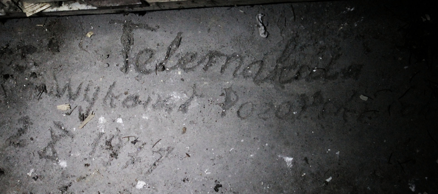 Napis wykonany w świeżym betonie w dniu mocowania w ołtarzu kościoła w Bisztynku  pancernego tabernakulum.
