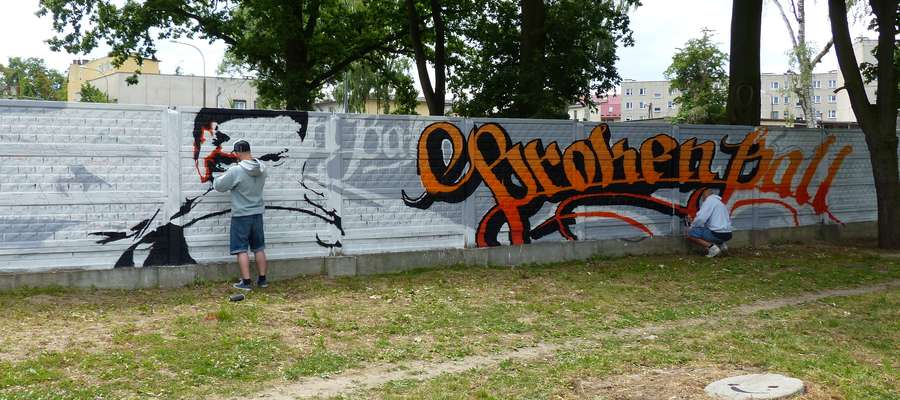Dziś (piątek, 19. czerwca), godzina 12:30 — Mateusz Wilczek i Maciej Gryko podczas pracy nad graffiti. Powstaje ono na murze znajdującym się tuż przy ścieżce pieszo-rowerowej nad rzeką Iławka