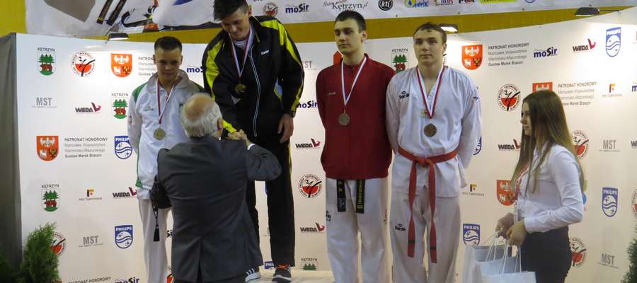 Artur Trumiński (Tygrys Kętrzyn, w ciemnym stroju) na najwyższym podium Młodzieżowych Mistrzostw Polski. Artur wygrał w kategorii do 87 kg.