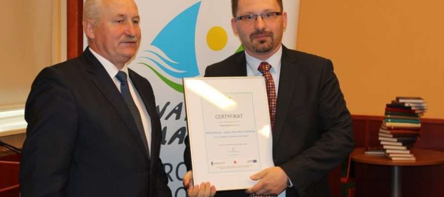 Pan Arkadiusz (z prawej) podczas odbioru certyfikatu z rąk Marszałka