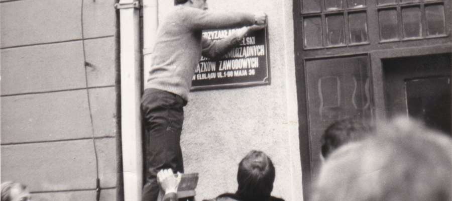 Zawieszenie tablicy Międzyzakładowego Komitetu Założycielskiego „Solidarności” w Elblągu na 1 Maja w 1980 roku. Każdy miał prawo wkręcić jedną śrubkę i nie do końca - tak aby starczyło dla wszystkich 