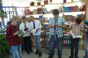 Tłumy chłopców w krawatach i muszkach w szkolnej bibliotece