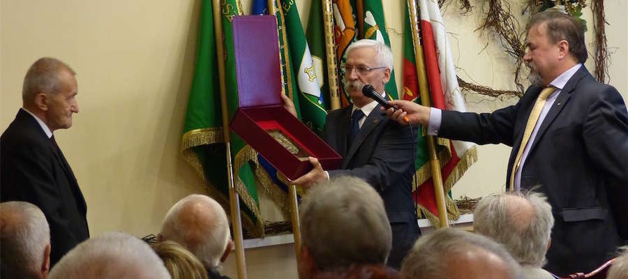 Prezes Wojewódzkiego Związku Pszczelarzy Józef Zysk (w środku) wręcza wyróżnienie Stefanowi Opalińskiemu, prezesowi iławskiego koła pszczelarzy