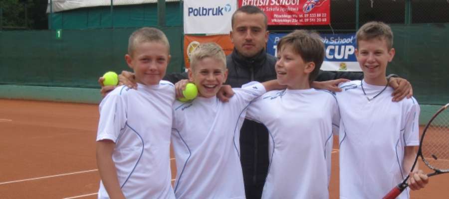 Uśmiechnięci młodzi tenisiści Budowlanych Olsztyn oraz ich trener Paweł Umbras
