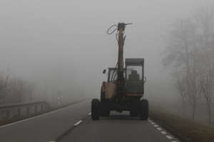 Nieoświetlony ciągnik we mgle na krajowej 57