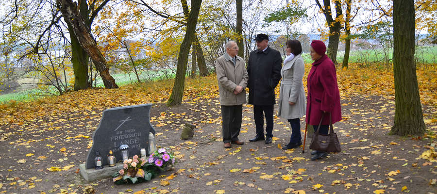 Delegacja na cmentarzyku w Łąkorku, którym opiekuje się wolontariusz z gminy Biskupiec