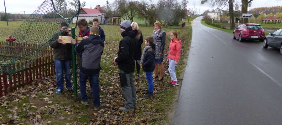 Dzieci pomagały pracownikom firmy Janpol w mocowaniu tabliczek do koszy
