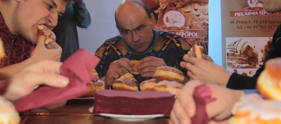 Jacek Bukowiecki (w środku) został zwycięzcą II mistrzostw "Gońca Bartoszyckiego" w jedzeniu pączków na czas