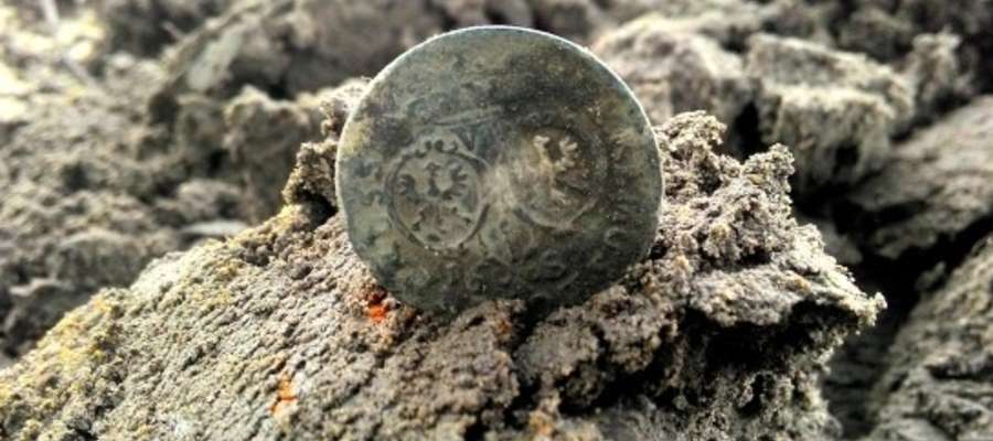 Tak wygląda srebrna moneta po 300 latach spędzonych w leśnej ziemi. To jeden z odkrytych szóstaków – srebrna moneta pruska o nominale 6 groszy z 1683 roku. Wybito ją w Królewcu