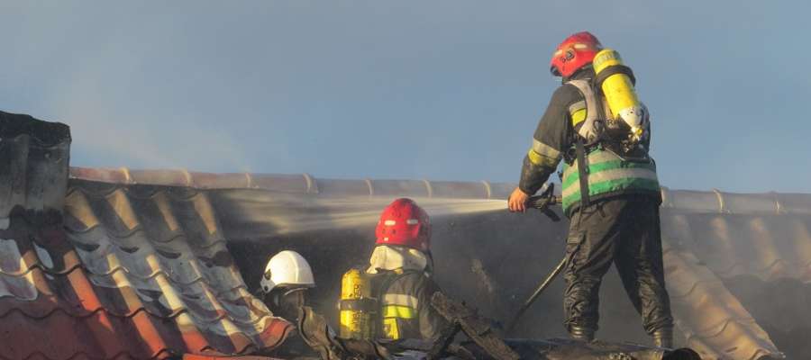 Na poddaszu spalonego budynku strażacy gasili tlące się jeszcze elementy dachu.