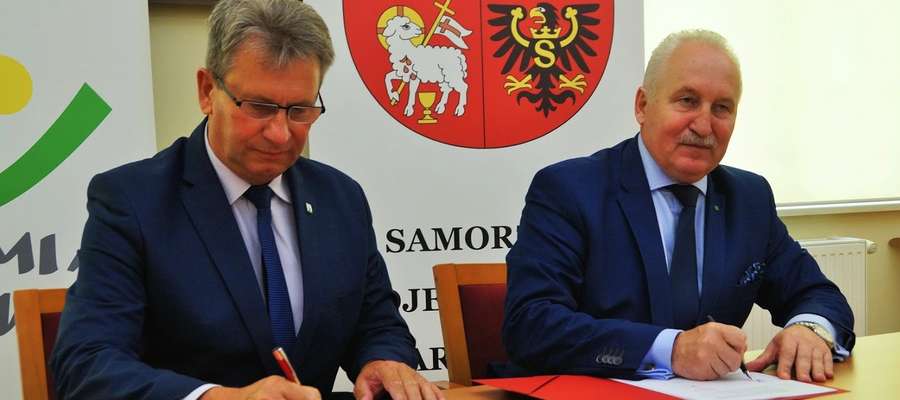 Burmistrz Susza Krzysztof Pietrzykowski (z lewej) i marszałek województwa Gustaw Marek Brzezin podpisują stosowne umowy