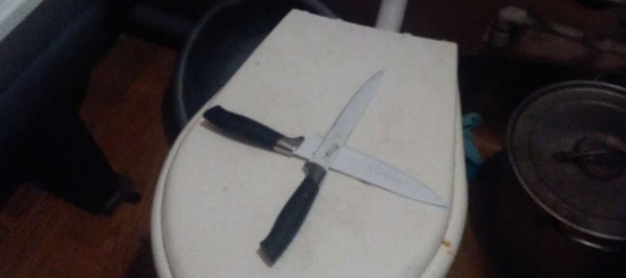 Na zdjęciu skrzyżowane noże, leżące na klapie sedesu