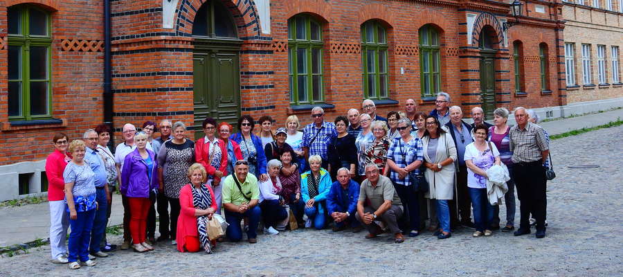 Wycieczka członków PZERiI z różnych miejscowości powiatu nowomiejskiego pod typową budowlą fabrycznej Łodzi