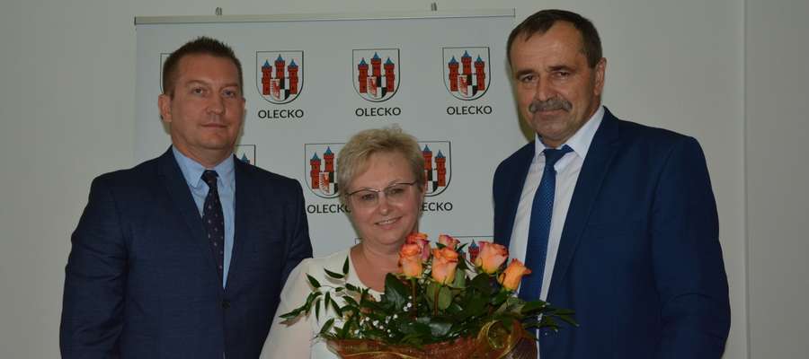  Burmistrz Wacław Olszewski (z prawej) i przewodniczący Rady Miejskiej w Olecku Wojciech Rejterada podziękowali Elżbiecie Rękawek za wieloletnią współpracę i kierowanie wydziałem edukacji 