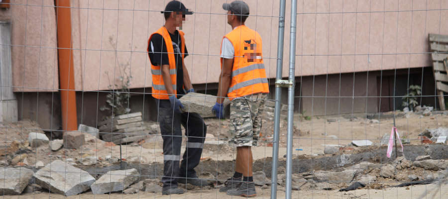 Pracownicy firmy demontują krawężniki zbudowane niezgodnie z projektem na ulicy Bema w Bartoszycach.