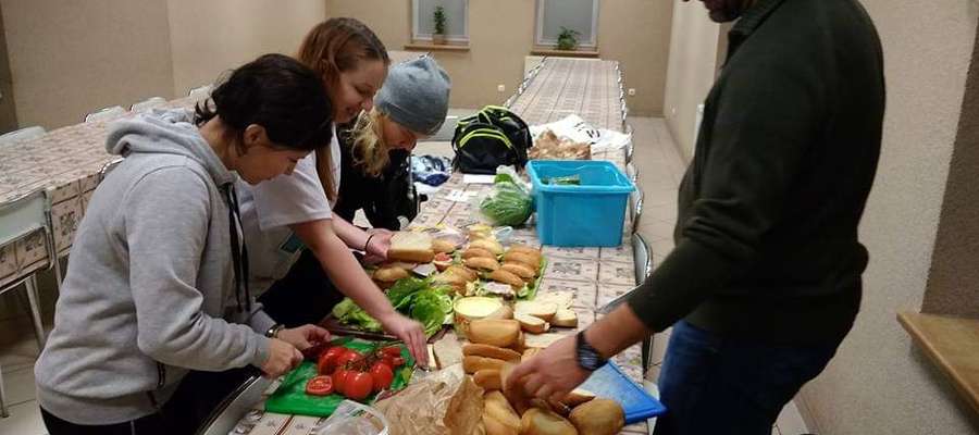 Wolontariusze podczas przygotowywania kanapek, którymi częstują potrzebujących na dworcu