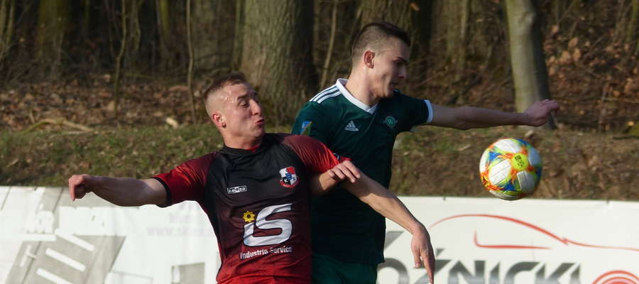 Michał Jankowski (GKS Wikielec, zielona koszulka) walczy o piłkę z obrońcą zespołu z Giżycka