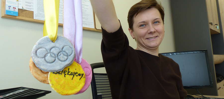 Joanna Mazurkiewicz, wicedyrektor Powiatowego Centrum Pomocy Rodzinie w Iławie, prezentuje medale, które dla uczestników biegu charytatywnego "Dobro Wraca" wykonali podopieczni Domu Dziecka w Kisielicach