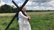 Samotny pielgrzym z krzyżem na ramionach