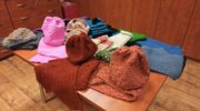 Uczestnicy zajęć w Środowiskowym Domu Samopomocy szyją czapki i szaliki