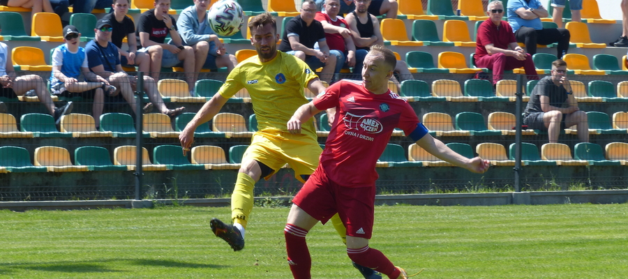Mateusz Jajkowski z GKS-u Wikielec (z prawej strony, czerwony strój) stara się powstrzymać zawodnika z Radomska