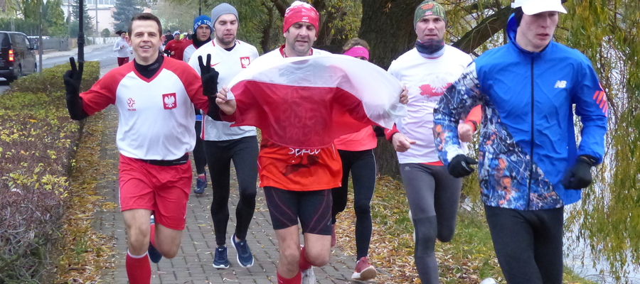Iława. Sobota 13 listopada, godzina 9.03 — biało-czerwoni biegacze i biegaczki na trasie parkrun Mały Jeziorak