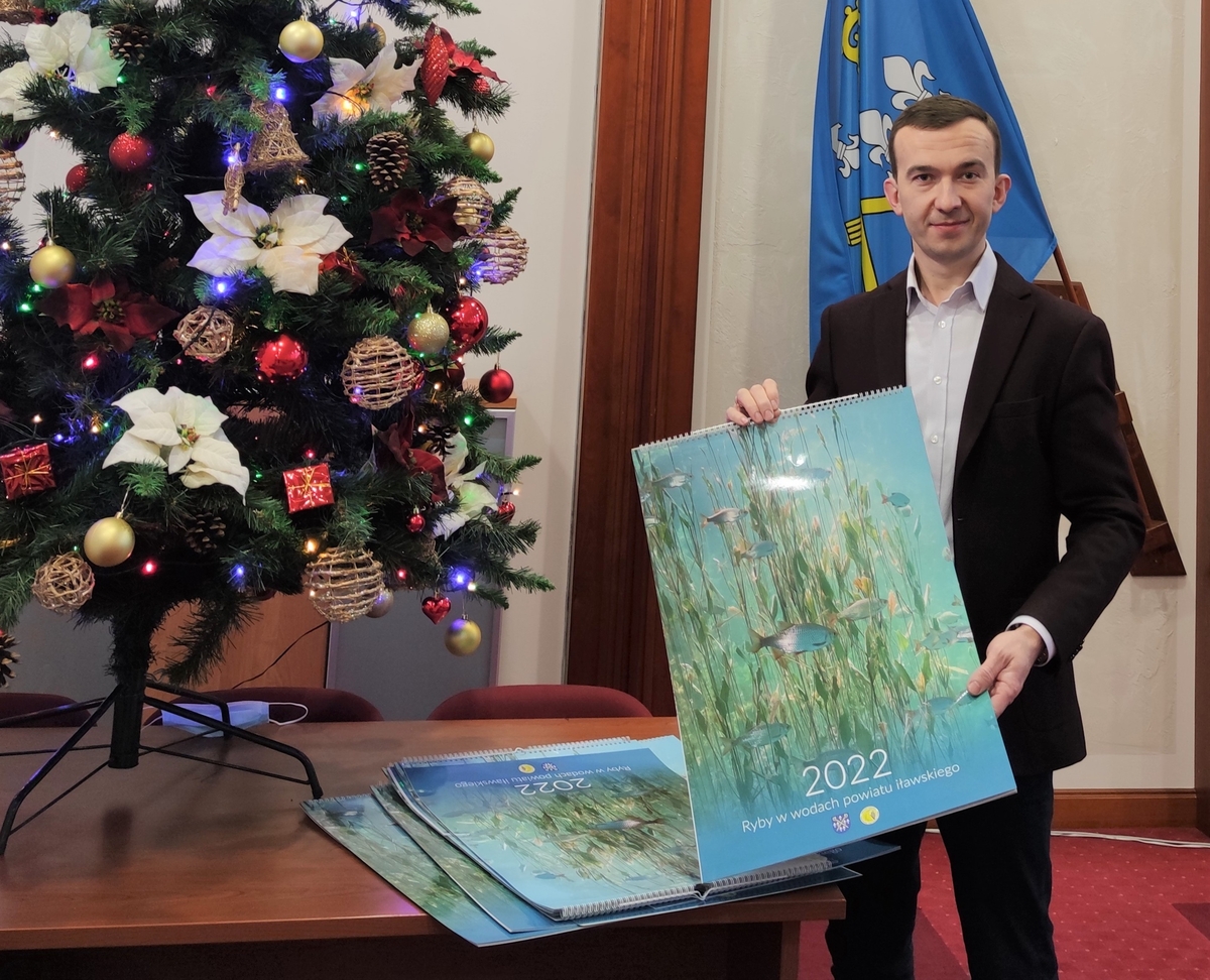 Mateusz Szauer, dyrektor wydziału ochrony środowiska i rolnictwa starostwa powiatowego w Iławie, prezentuje kalendarz. Okładkę zdobi ławica wzdręg