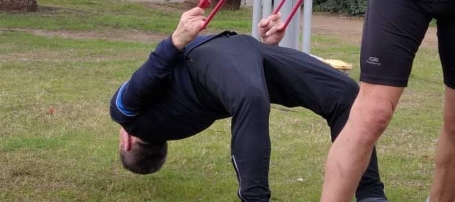 Mirosław Figat, były maratończyk (62 lata) robi "mostek" podczas treningu z gumami. Tu akurat asekuruje go Paweł Hofman, autor "Przewodnika po bieganiu"