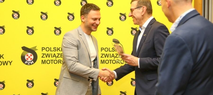 Adam Binięda odbiera gratulacje od prezydenta Olsztyna Piotra Grzymowicza