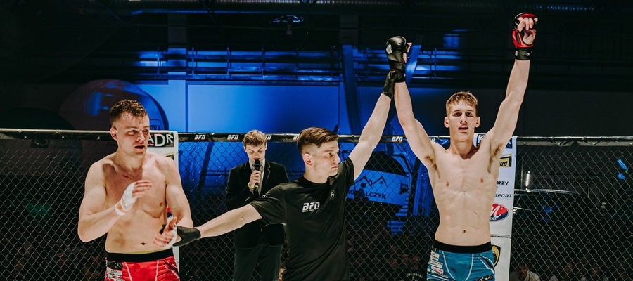 Łukasz Makowski (Arrachion Iława, z rękoma w górze) tuż po ogłoszeniu wyniku walki z Kacprem Salwinem, podczas gali MMA Blood Fight Night w Wyszkowie