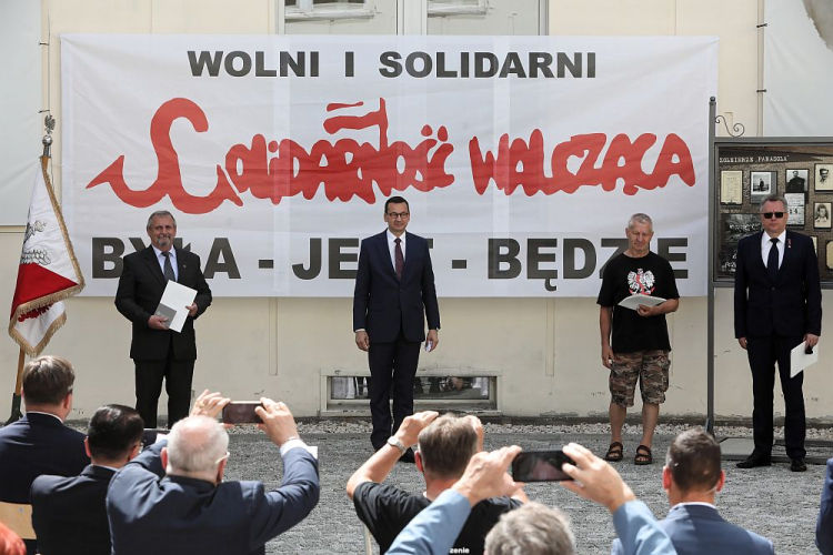 Premier Mateusz Morawiecki (2L) oraz byli działacze opozycji Janusz Gajewski (L), Zbigniew Rutkowski (P) oraz Krzysztof Wolf (2P) podczas uroczystości przekazania archiwum Solidarności Walczącej do zbiorów Archiwum Akt Nowych. 