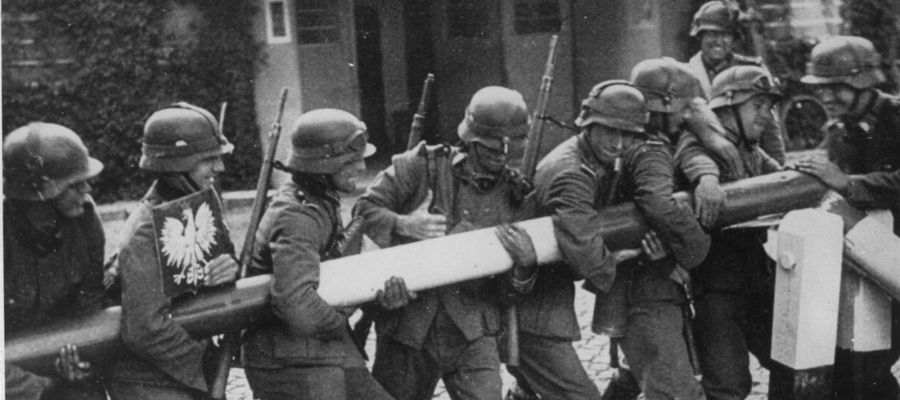 Niemieccy żołnierze inscenizują dla celów propagandowych scenę łamania polskiego szlabanu granicznego w Kolibkach. Wrzesień 1939 r. (AIPN)
