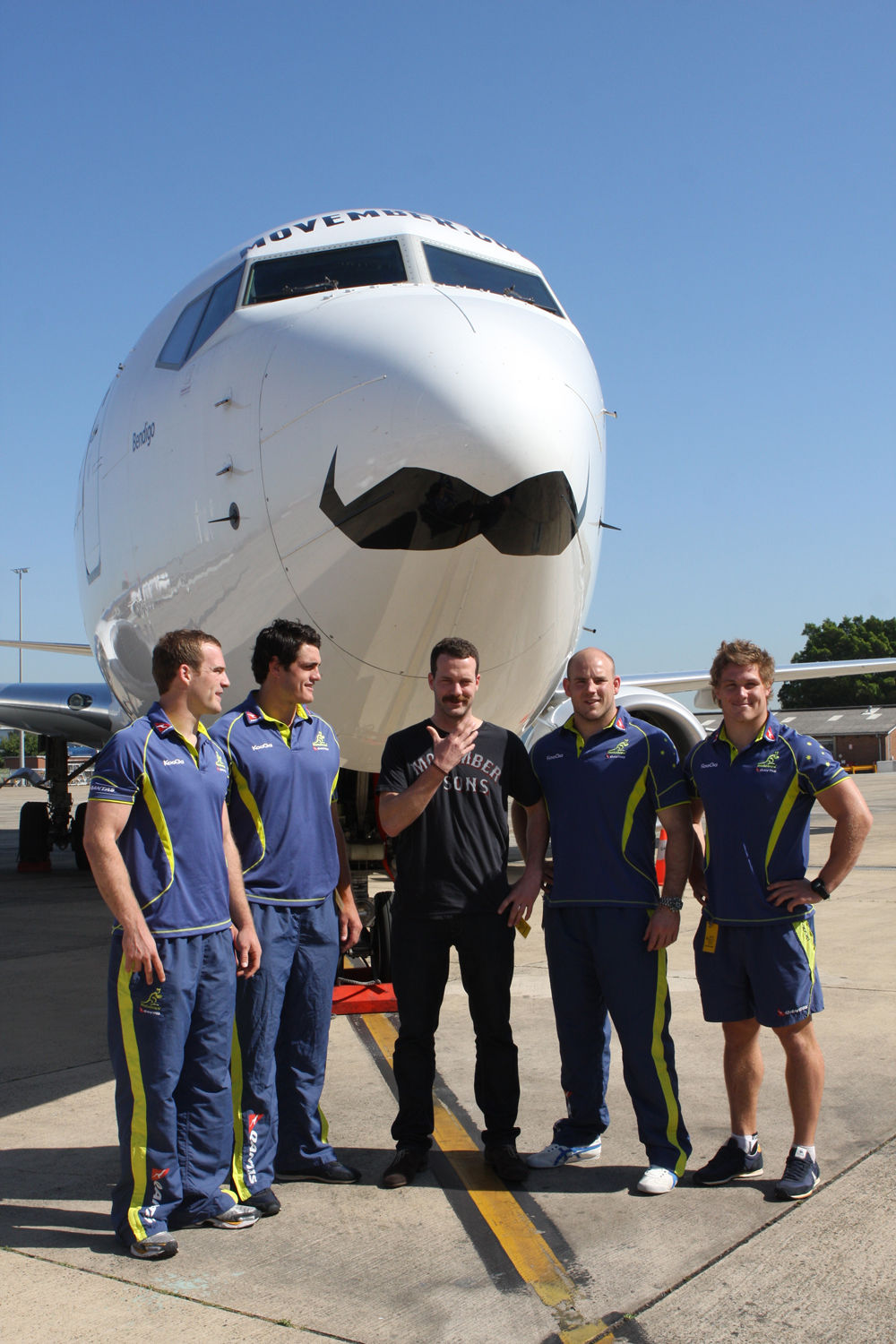 Członkowie australijskiej drużyny narodowej związku rugby podczas odsłonięcia promocyjnie udekorowanego samolotu Boeing 737-800 podczas Movember w 2011 r.