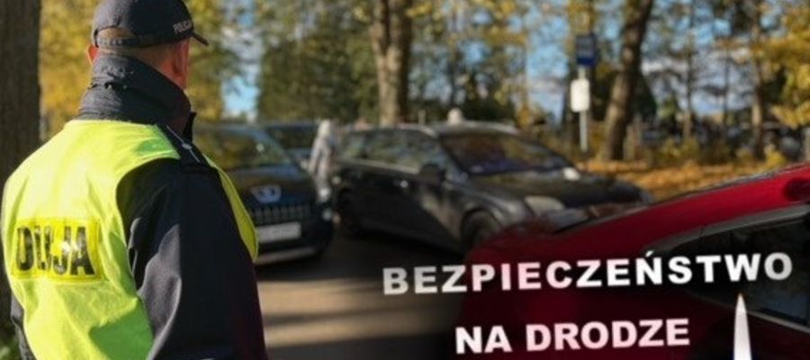 Policjant na cmentarzu obok zaparkowanych samochodów 