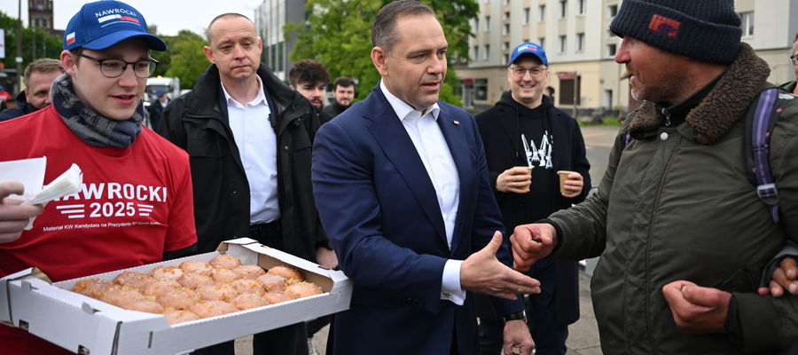 Karol Nawrocki podczas częstowania drożdżówkami przed dworcem stacji kolejowej Gdańsk Wrzeszcz.