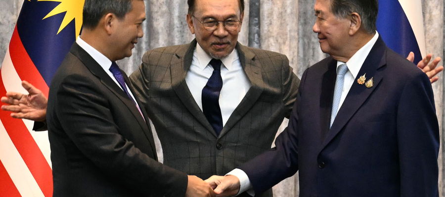 Premier Kambodży Hun Manet (L) i pełniący obowiązki premiera Tajlandii Phumtham Wechayachai (R) podają sobie ręce, a premier Malezji Anwar Ibrahim (C) obejmuje ich ramionami po konferencji prasowej po rozmowach na temat możliwego zawieszenia broni między Tajlandią a Kambodżą w Putrajaya, Malezja, 28 lipca 2025 r. 
